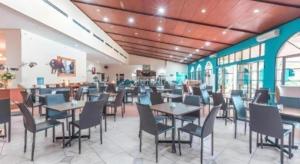 a dining room with tables and chairs in a restaurant at Ole Suite Hotel in Bogor