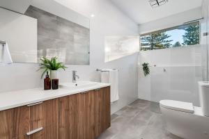 a bathroom with a sink and a toilet and a window at Belle Escapes - Henley Beach House in Henley Beach +37 photos