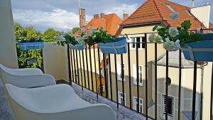 a balcony with chairs and potted plants on a fence at Pomorskie Apartamenty Ceynowy 1 Deluxe in Sopot