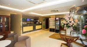 a lobby with a vase of flowers on a table at GreenTree Inn Luoyang Zhongzheng Street Express Hotel in Luoyang