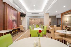 a dining room with tables and green chairs at Jinjiang Inn Select Shanghai Expo Park Dezhou Road in Shanghai