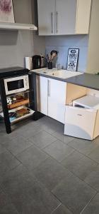 a kitchen with white cabinets and a counter top at B&B Evasion Appartment in Mons