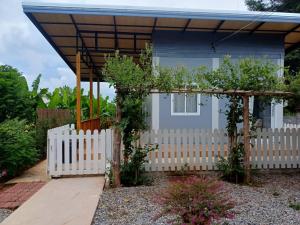 une clôture blanche devant une petite maison dans l'établissement โฮมสเตย์ ยายหนั่น, à Chaiyaphum
