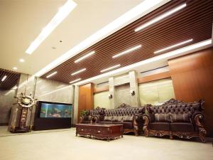a living room with a leather couch and a clock at GreenTree Inn Xi'an Yanta District Dayanta Furongyuan Hotel in Xi'an