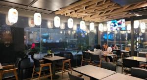 two people sitting at tables in a restaurant at Neca Reiche in Hat Yai