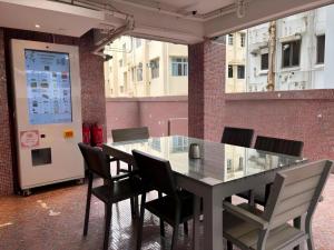 a table and chairs in a room with a large window at Acesite Knutsford Hotel in Hong Kong