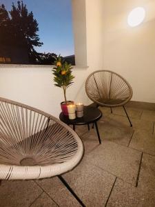 two chairs and a table with a plant in a room at Zentrumsnah, Balkon, Amazon Prime,Self Checkin in Augsburg