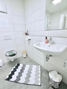 a white bathroom with a sink and a toilet at Zentrumsnah, Balkon, Amazon Prime,Self Checkin in Augsburg