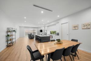 a dining room and living room with a table and chairs at Belle Escapes - Henley Beach House in Henley Beach