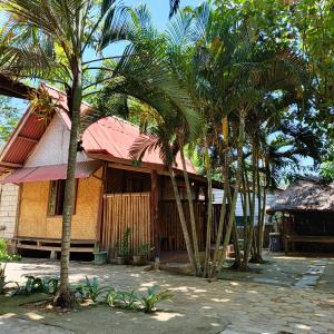 a building with palm trees in front of it at Sasak Lombok Bungalow in Kuta Lombok