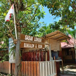 a sign in front of a building with a flag at Sasak Lombok Bungalow in Kuta Lombok