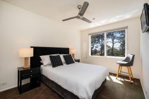 a bedroom with a bed and a window and a chair at Villa Solare - Pet friendly Retreat with Pool and Spa in Mount Martha +21 photos