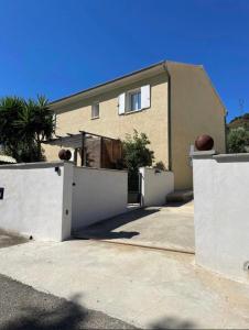 a house with two white fences in front of it at Appartement deux chambres spacieux avec jardin et entièrement privatif dans lotissement très calme in Biguglia