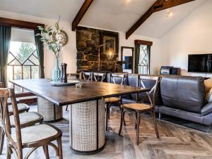 une salle à manger avec une grande table et des chaises en bois dans l'établissement Lakeside haven cottage - Macedon ranges, à Riddell