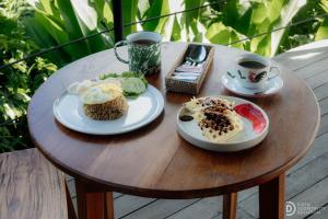 a table with two plates of food and two cups of coffee at Green Lava Lake View Glamping Bedugul By IHM in Bedugul