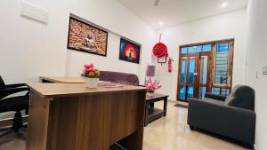a living room with a desk and chairs at The Chalet in Pūrnānkuppam