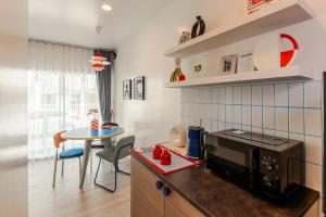 a small kitchen with a table and a microwave at anhaus chiangrai in Chiang Rai