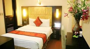 a bedroom with a bed and a vase of flowers at New Moon Hotel in Hanoi +190 photos