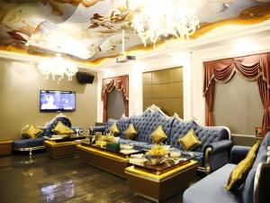 Una sala de estar con un sofá azul y un televisor. en Landmark International Hotel Nanwan, en Zhuhai