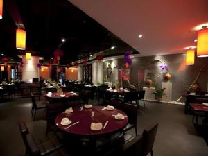 Un restaurante con mesas y sillas en una sala. en Landmark International Hotel Nanwan, en Zhuhai