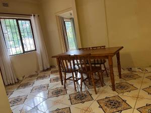 Un comedor con mesa y sillas de madera. en Sunwich Beach Home, en Port Shepstone