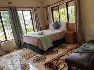 Un dormitorio con una cama y dos ventanas. en Sunwich Beach Home, en Port Shepstone