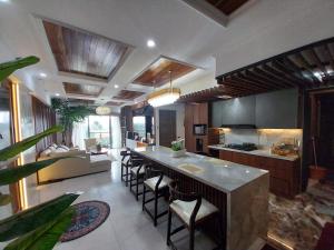 a kitchen with a large island with bar chairs at Apartemen SKY HOUSE BSD in Samporo