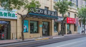 a city street with a building with signs on it at Xana Hotelle· Tianjin Railway Station Jinwan Square Binjiang Avenue in Tianjin