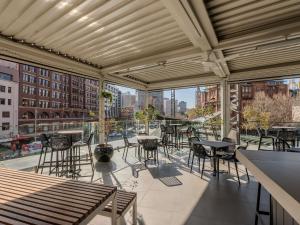 a balcony with tables and chairs and a view of a city at Mercure Sydney in Sydney