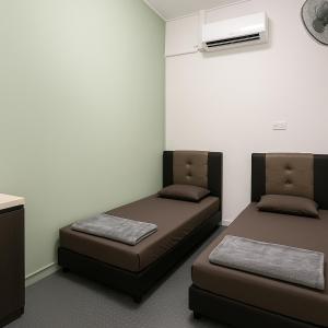 ein Zimmer mit zwei Betten und einer Klimaanlage in der Unterkunft TK Homie in Tanjung Karang