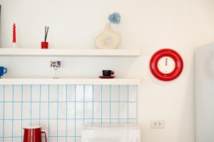 a kitchen with a sink and a red clock at anhaus chiangrai in Chiang Rai +136 photos