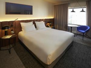 a large white bed in a hotel room at Pullman Sao Paulo Ibirapuera in Sao Paulo