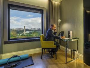 a man sitting at a desk in a room with a window at Pullman Sao Paulo Ibirapuera in Sao Paulo +197 photos