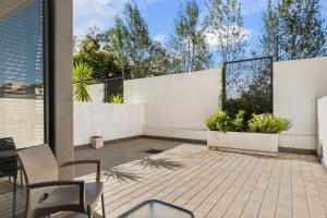 Un patio con cerca blanca y dos plantas. en Easy Stay - The Vantage Rosebank, en Johannesburgo