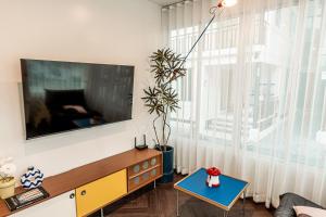 a living room with a large window and a tv at anhaus chiangrai in Chiang Rai