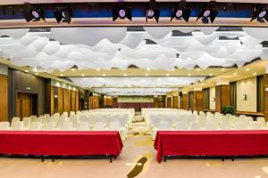 a banquet hall with white chairs and red tables at Yitel Tai'an Taishan Hongmen Daimiao in Tai'an