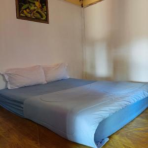 a bed in a room with a blue bedsheet at Sasak Lombok Bungalow in Kuta Lombok