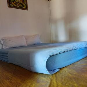 a bed with a blue comforter on the floor at Sasak Lombok Bungalow in Kuta Lombok +31 photos