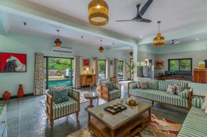 a living room with couches and a table at Villasita Udaipur in Udaipur