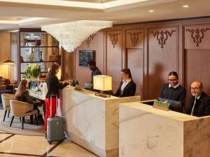 a group of people sitting at a reception desk in a lobby at Sofitel Paris Baltimore Tour Eiffel in Paris