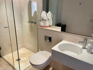 a bathroom with a sink and a toilet and a mirror at CBD Heritage King Suite - Spa Bath, Private Deck and Laundry in Sydney