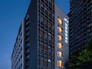 a tall building with its lights on at Home Inns Plus Shanghai Xujiahui Branch in Shanghai