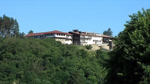 a building on top of a hill with trees at Motel Koziyat Rog in Malko Tŭrnovo