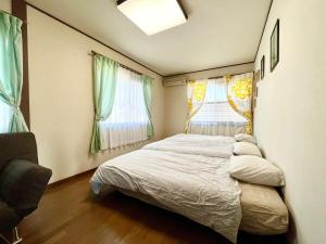 a bedroom with a bed and two windows at Kamakura Guest House 3 Bedrooms, Sleeps 10 in Kamakura