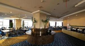 a lobby with a restaurant with tables and chairs at Green Tree Eastern Hefei Dahua International Harbor Hotel in Hefei