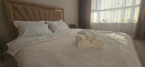 two towels are sitting on a white bed at Apartaments Astana in Astana