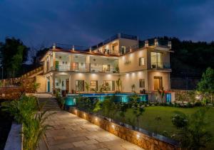 a large house with a swimming pool at night at Villasita Udaipur in Udaipur