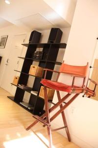 a wooden chair sitting in a room with a shelf at Best Location In South Beach Steps To Everything! in Miami Beach