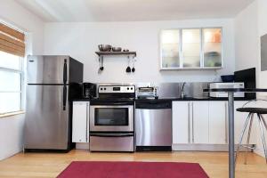 a kitchen with white cabinets and stainless steel appliances at Best Location In South Beach Steps To Everything! in Miami Beach