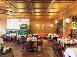 a restaurant with tables and chairs in a room at Mercure Hotel am Messeplatz Offenburg in Offenburg